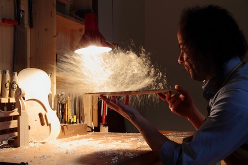 Immagine con artigiano, luce, artigianato, legno, mani, uomo, polvere, lavoro, soffiare, tavolo, liutaio, violino, segatura