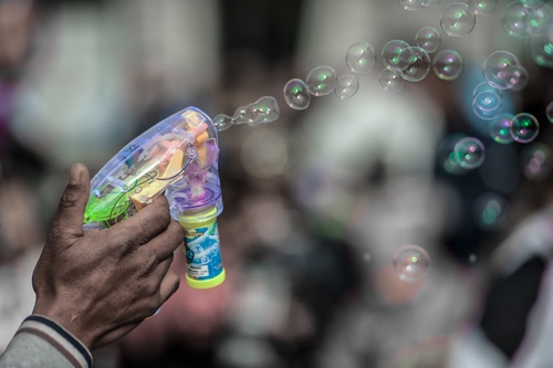 Immagine con bolle, mano, sapone, pistola, sfere, sfocato, dita, giocattolo, colori, riflessi, tante, riflesso